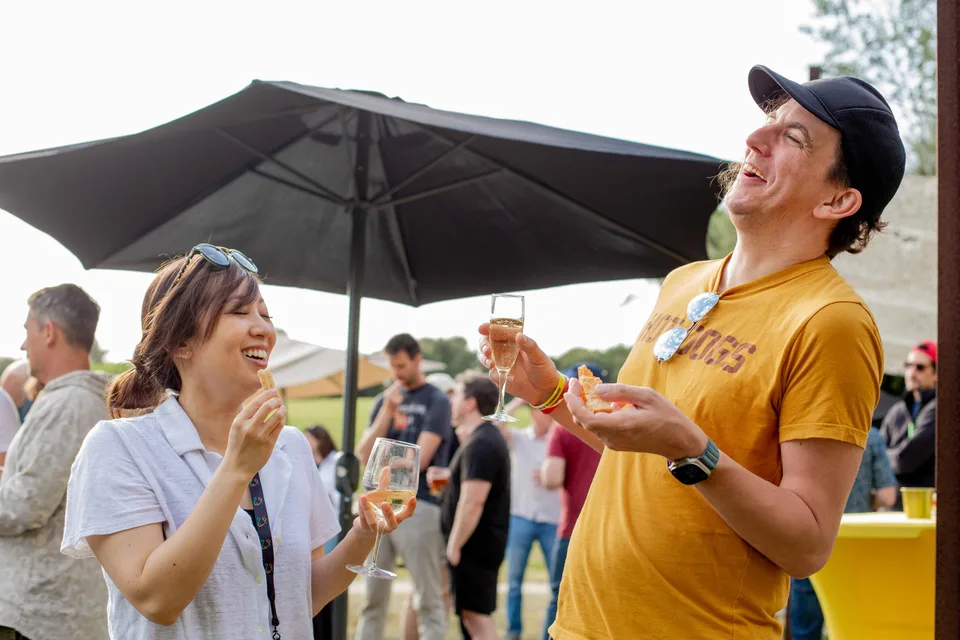 Two Close teammates laughing together over drinks at the annual retreat